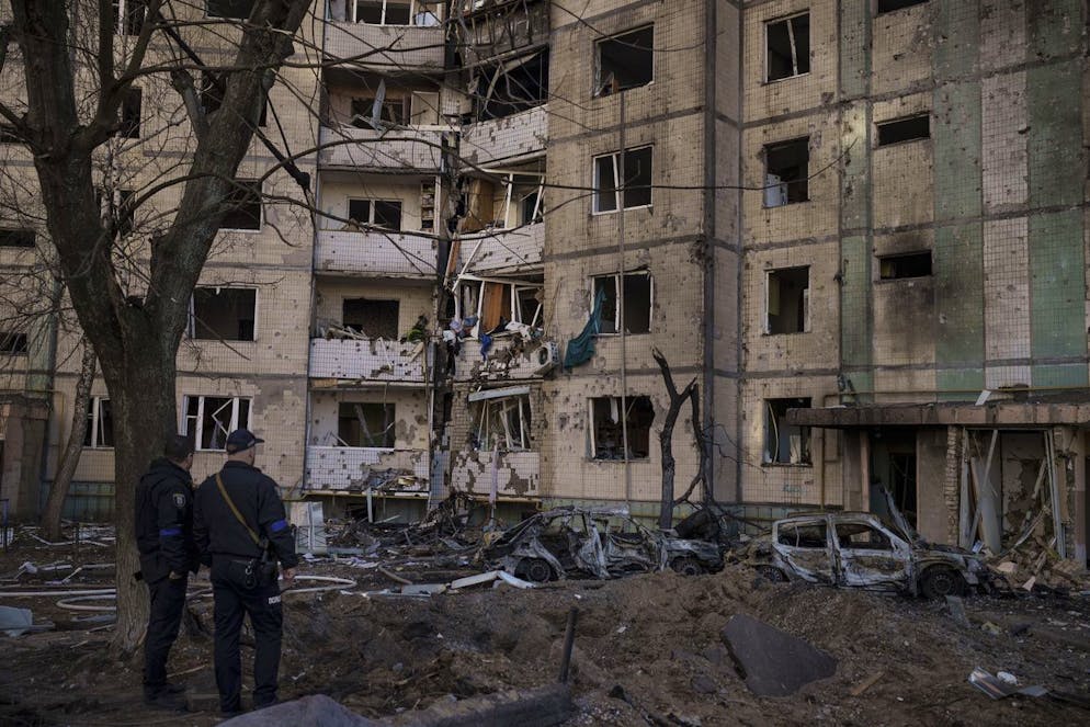 Ukrainian policemen look at a heavily damaged building after bombing in Kyiv, Ukraine, Sunday, March 20, 2022. (AP Photo/Felipe Dana)