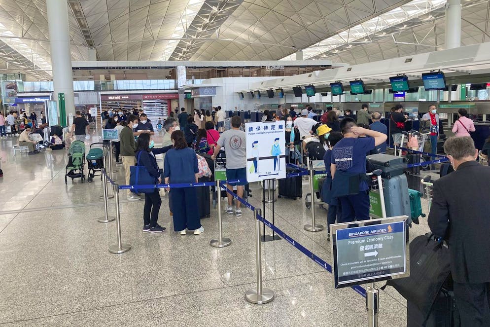 Passengers wait in long queues for a single flight to Singapore on Monday, March 14, 2022 at the International Airport in Hong Kong, in an empty departure room that is usually buzzing with passengers.  The landscape of China is witnessing widespread upheaval.  New infections in its major cities.  That number is small compared to Hong Kong, which recorded 32,000 cases on Sunday.  (AP Photo / YK Chan)