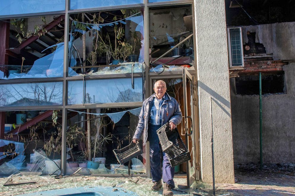 A man walks next to an apartments building hit by shelling in Kharkiv, Ukraine, Sunday, March 20, 2022. (AP Photo/Andrew Marienko)