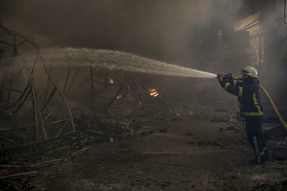 A Ukrainian firefighter hoses down a destroyed warehouse after a Russian bombardment on the outskirts of Kyiv, Ukraine, Thursday, March 24, 2022. Ukraine President Volodymr Zelenskyy called on people worldwide to gather in public Thursday to show support for his embattled country as he prepared to address U.S. President Joe Biden and other NATO leaders gathered in Brussels on the one-month anniversary of the Russian invasion. (AP Photo/Vadim Ghirda)