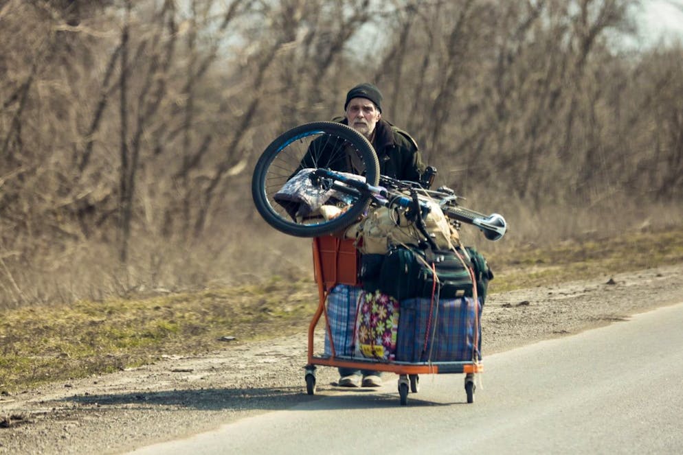 A local resident pushes a supermarket cart with his belongings leaving Mariupol for some peaceful place on the territory which is under the Government of the Donetsk People's Republic control, on the outskirts of Mariupol, Ukraine, Thursday, March 24, 2022. (AP Photo/Alexei Alexandrov)