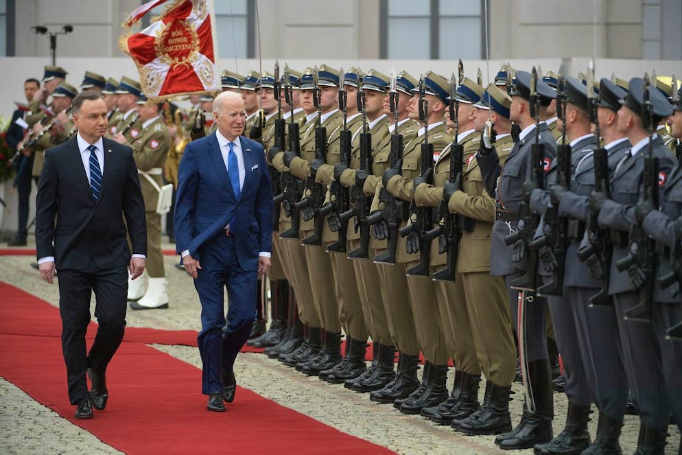 epa09850742 Polish President Andrzej Duda (L) and US President Joe Biden (R) review an honor guard during an official welcome ceremony at the Presidential Palace in Warsaw, Poland, 26 March 2022. US President Biden arrived in Poland for a two-days visit during which he is scheduled to hold talks with his Polish counterpart and make an address at the Royal Castle in Warsaw. Biden is coming to Poland straight from Brussels, where he attended an extraordinary Nato summit, a European Council meeting and a G7 summit on 24 March. EPA/Marcin Obara POLAND OUT