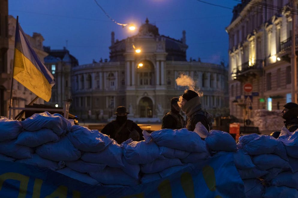A Ukrainian soldier smokes as he and other soldiers stand guard behind sandbags and in front of the National Academic Theatre of Opera and Ballet building, in Odesa, Ukraine, Thursday, March 24, 2022. The city of Odesa is prepared for a possible Russian offensive. (AP Photo/Petros Giannakouris)