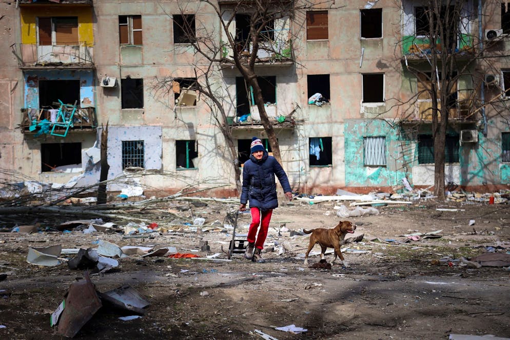 Ein Mann und sein Hund inmitten der Zerstörung am Stadtrand von Mariupol.