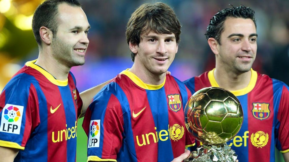 epa02527015 FC Barcelona's Argentinian striker Lionel Messi (C) poses with the Ballon d'Or trophy next to his team-mates Xavi Hernandez (R) and Andres Iniesta (L) before their Spanish King Cup quarter final first leg soccer match against Betis in Nou Camp stadium, Barcelona, north-eastern Spain, 12 January 2011. EPA/ANDREU DALMAU