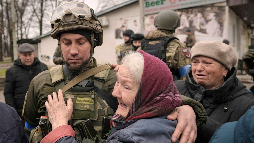 Eine Frau umarmt einen ukrainischen Soldaten, nachdem ein Konvoi von Militär- und Hilfsfahrzeugen in dem ehemals russisch besetzten Kiewer Vorort Butscha eingetroffen ist.