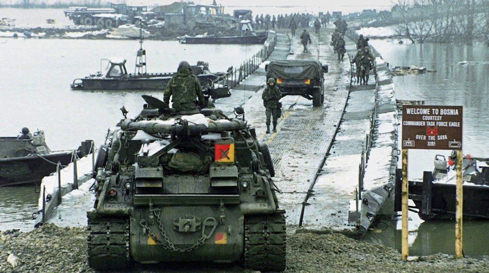 Die ersten Panzerfahrzeuge der Implementation Force (Ifor) unter Nato-Fuehrung ueberqueren die vom US Army Corps of Engineers gelegte Ponton-Bruecke ueber die Sava, den Grenzfluss zwischen Bosnien und Kroatien, beim kroatischen Zupanja, aufgenommen am 31. Dezember 1995. Seit 1993 in Bosnien operierend, fuehrt die Nato hier seit Ende 1995 eine der groessten Operationen ihrer Geschichte durch. Mit der Durchsetzung der militaerischen Bestimmungen des Abkommens von Dayton wurde Ende 1995 die gegen 60000 Soldaten starke Implementation Force (Ifor) unter Nato-Fuehrung betraut. (KEYSTONE/AP Photo/L. Sladky)