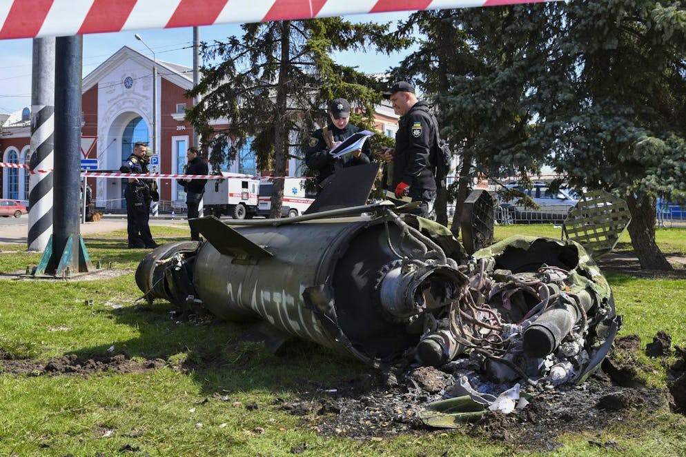 Ukrainian servicemen stand next to a fragment of a Tochka-U missile with a writing in Russian 
