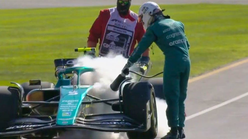 Sebastian Vettel kümmert sich gleich selbst um sein qualmendes Auto.