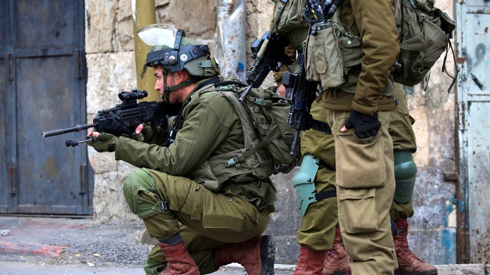 epa09801356 An Israeli soldier aims his weapon during clash with Palestinians following a protest against Israeli settlements in the West Bank city of Hebron, 04 February 2022. Clashes between the Palestinian majority population and Jewish settlers in Hebron often flare up following the Friday prayers due to the massive presence of Israeli forces. EPA/ABED AL HASHLAMOUN