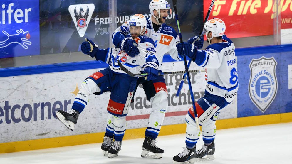 l'attaquant des ZSC Denis Malgin, a gauche, celebre son goal (2-2) avec ses coequipiers, le defenseur des ZSC Christian Marti, au centre, l'attaquant des ZSC Marco Pedretti, a droite, lors de la rencontre de playoff 1/2 de final acte 3 du championnat suisse de hockey sur glace de National League LNA, entre le HC Fribourg-Gotteron, HCFG, et le ZSC Lions, ce mardi 12 avril 2022 a la patinoire de la BCF Arena a Fribourg. (KEYSTONE/Anthony Anex)