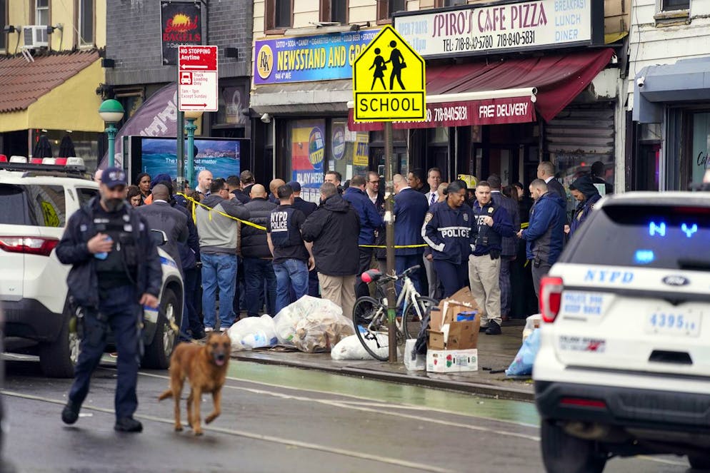New York City Police Department personnel gather at the entrance to a subway stop in the Brooklyn borough of New York, Tuesday, April 12, 2022. Five people were shot Tuesday morning at a subway station in Brooklyn, New York, law enforcement sources said. (AP Photo/John Minchillo)