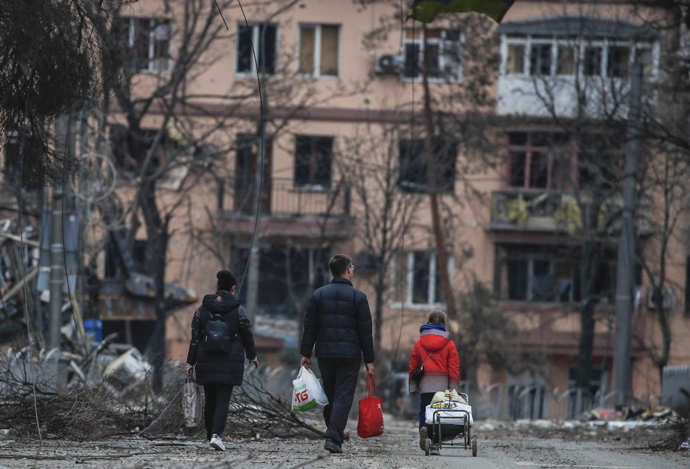 Alcune persone del luogo camminano per le vie di Mariupol.