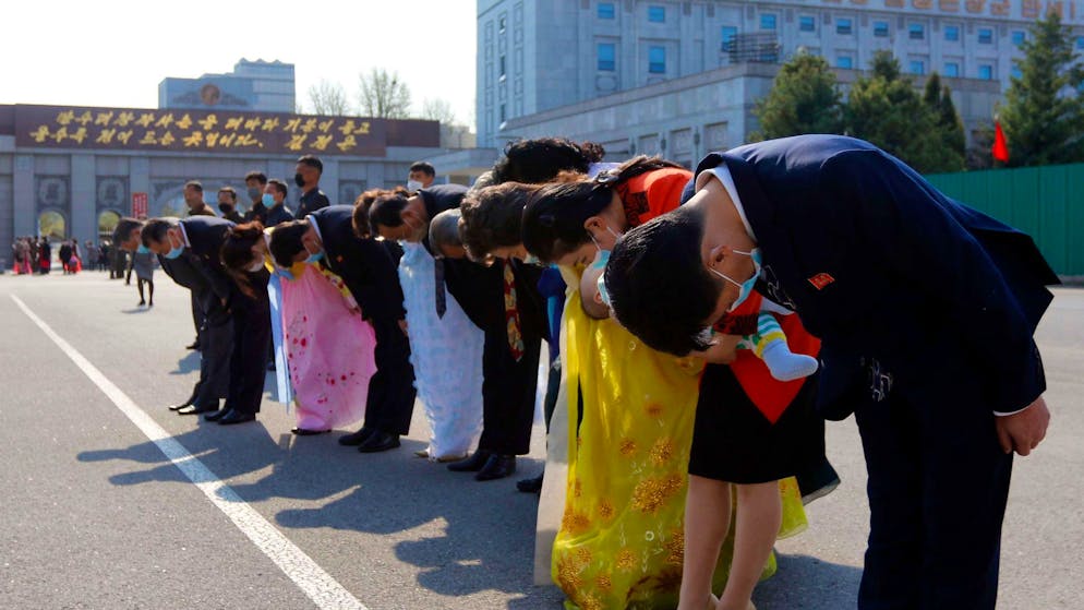 People bow in front of statues of late North Korean leaders Kim Il Sung and Kim Jong Il.  A 22-year-old North Korean man was publicly hanged for watching South Korean movies and music.