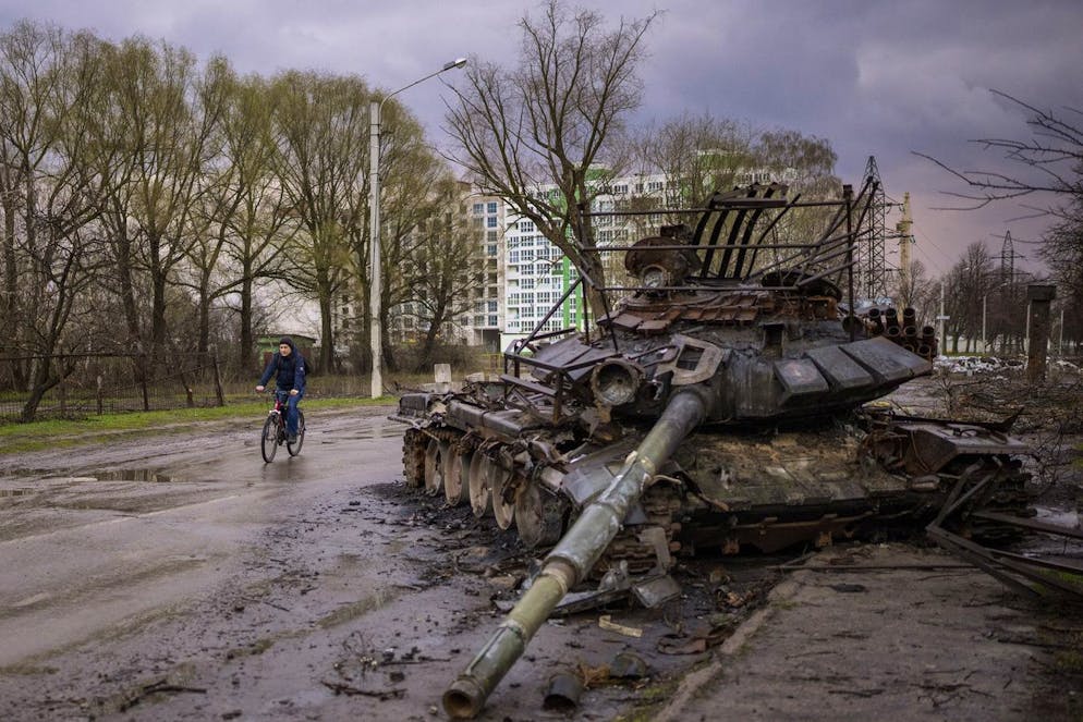 A man rides his bicycle next to a destroyed Russian tank in Chernihiv, Ukraine, on Thursday, April 21, 2022. (AP Photo/Emilio Morenatti)