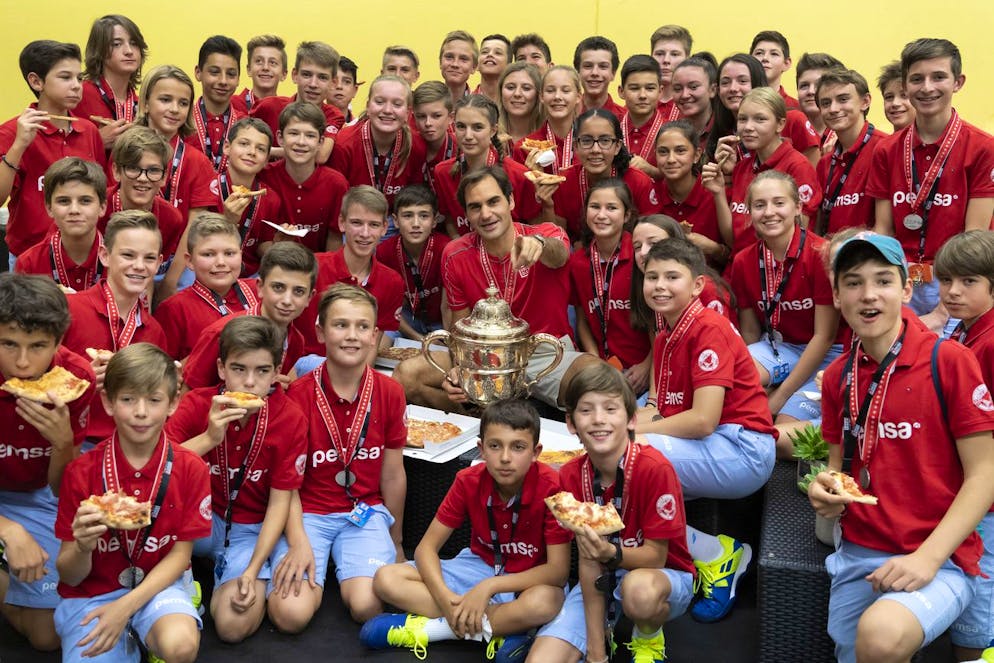 Switzerland's Roger Federer eats pizza with the ball kids after winning his tenth title at the Swiss Indoors tennis tournament at the St. Jakobshalle in Basel, Switzerland, on Sunday October 27, 2019. (KEYSTONE/Georgios Kefalas)
