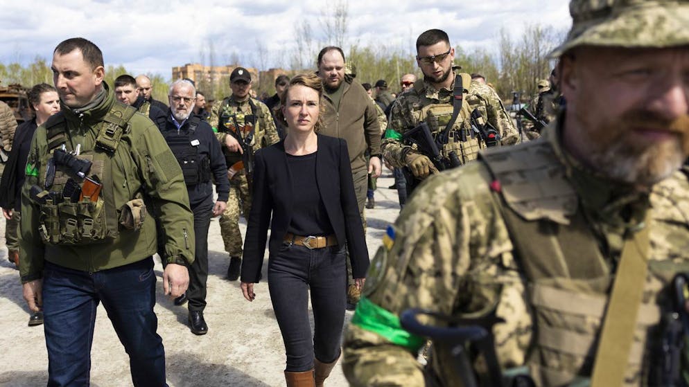 Irene Kaelin, President of the Swiss National Assembly, center, surrounded by members of the Ukrainian military, leaves the Hostomel airfield near Kiev, Ukraine, which was destroyed by Russian invaders, Wednesday, April 27, 2022. (KEYSTONE/Peter Klaunzer)