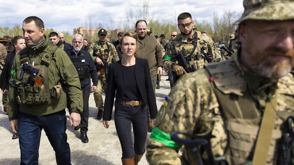 Irene Kaelin, President of the Swiss National Assembly, center, surrounded by members of the Ukrainian military, leaves the Hostomel airfield near Kiev, Ukraine, which was destroyed by Russian invaders, Wednesday, April 27, 2022. (KEYSTONE/Peter Klaunzer)