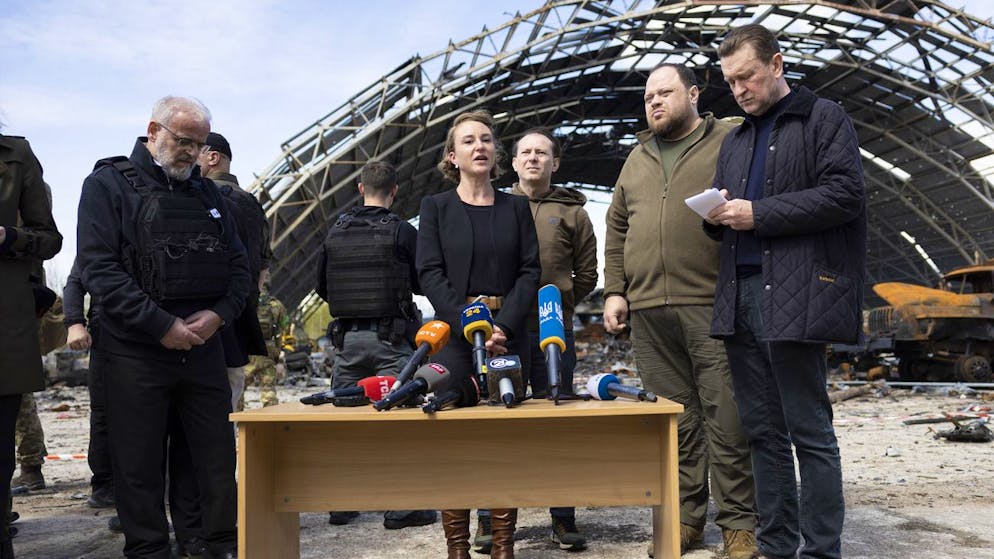 Irene Kaelin, President of the Swiss National Assembly, center, speaks beside Ruslan Stefanchuk, President of the Ukrainian Parliament, (2-R) on the Hostomel airfield near Kiev, Ukraine, which was destroyed by Russian invaders, Wednesday, April 27, 2022. (KEYSTONE/Peter Klaunzer)