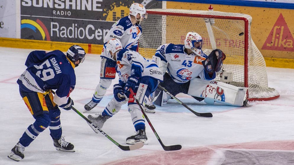 Dario Simion, links, von Zug schiesst das Tor zum 2:1 gegen Torhueter Jakub Kovar, rechts, vom ZSC beim Eishockey Playoff-Finalspiel, Spiel 5, der National League zwischen dem EV Zug und den ZSC Lions am Mittwoch, 27. April 2022 in Zug. (KEYSTONE/Urs Flueeler).