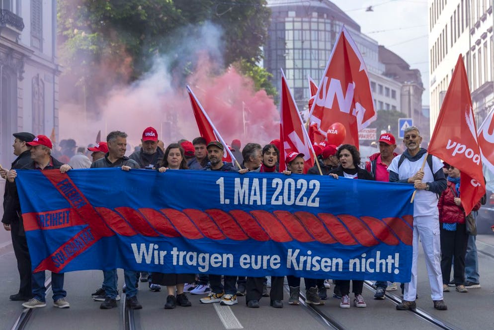An einer Kundgebung zum Tag der Arbeit demonstrieren Menschen mir Transparenten in Basel, am Sonntag, 1. Mai 2022. (KEYSTONE/Georgios Kefalas)