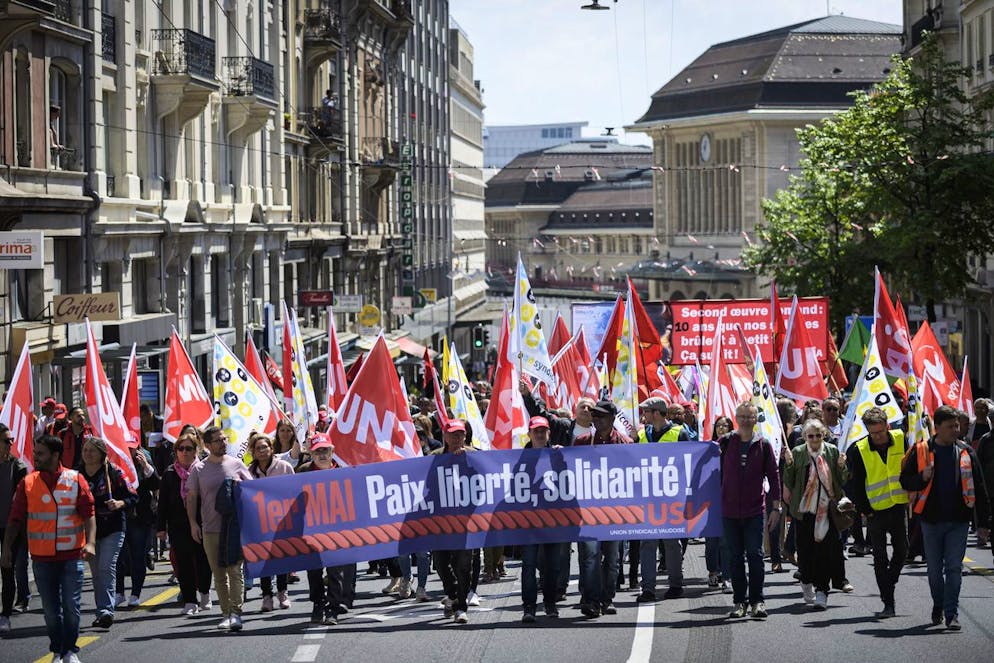 Des personnes defilent lors de la manifestation du 1er Mai, la fete du travail, ce dimanche 1 mai 2022 dans les rues de Lausanne. Environ 500 manifestants ont defiles dans les rues de la capitale vaudoise. (KEYSTONE/Gabriel Monnet)