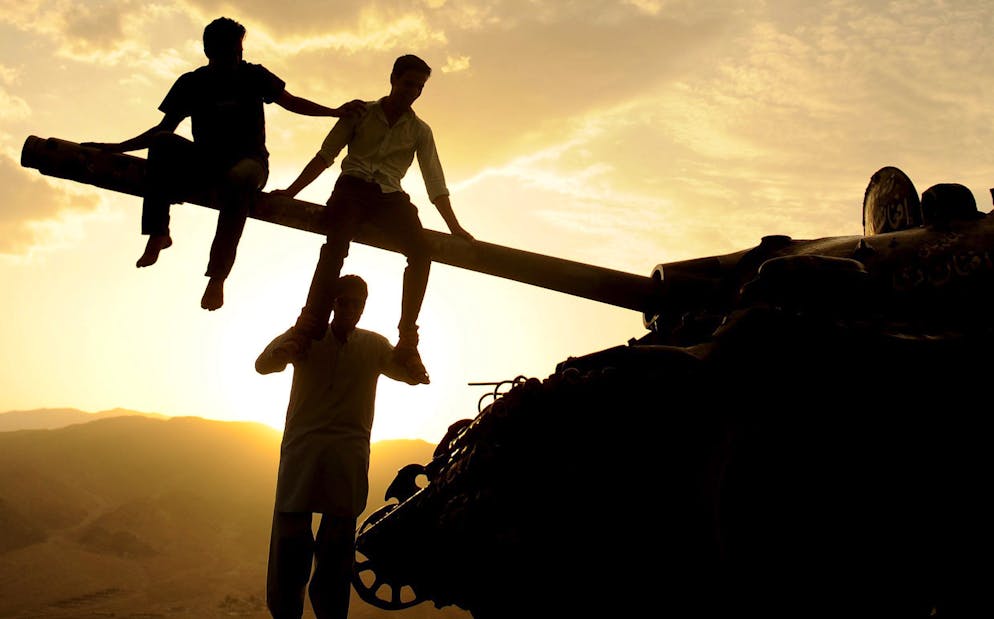 epa04373565 Afghan youths sit on the gun barrel of a Soviet-era tank, in Kabul, Afghanistan, 29 August 2014. Soviet troops occupied the country for ten years from 1979 to 1989. EPA/JAWAD JALALI