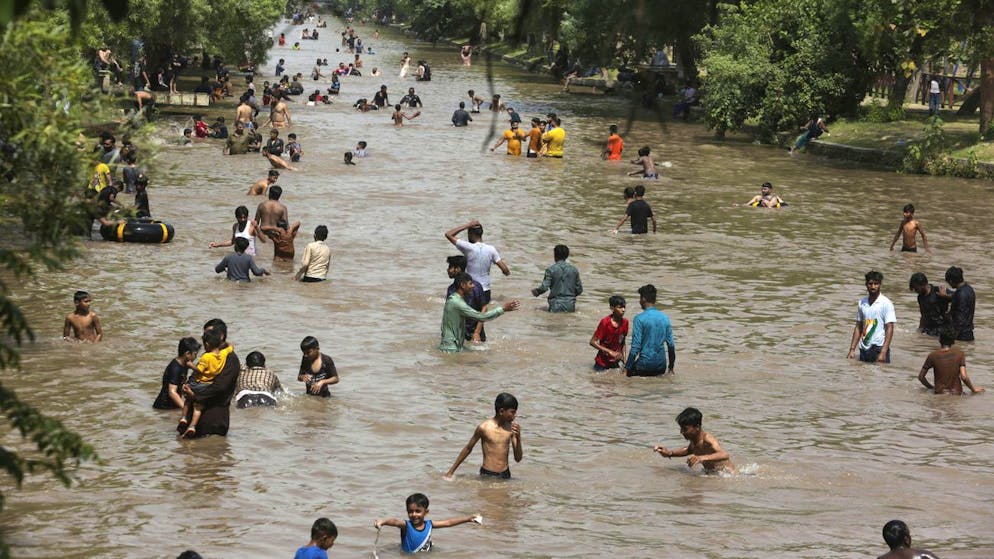 People swim in a canal to cool themselves as temperature reached 38 C (99 F) in Lahore, Pakistan, Sunday, May 8, 2022. (AP Photo/K.M. Chaudary)