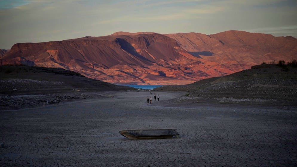 A formally sunken boat sits on cracked earth hundreds of feet from what is now the shoreline on Lake Mead at the Lake Mead National Recreation Area, Monday, May 9, 2022, near Boulder City, Nev. Lake Mead is receding and Sin City is awash with mob lore after a second set of human remains emerged within a week from the depths of the drought-stricken Colorado River reservoir just a short drive from the Las Vegas Strip. (AP Photo/John Locher)