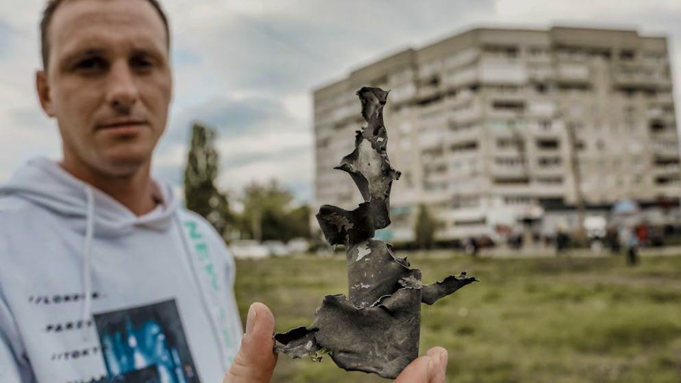 In Charkiw hält ein Mann einen Munitionssplitter vor die Kamera.
