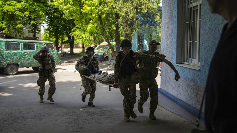 Ukrainische Soldaten transportieren am 9. Mai 2022 in der Region Donezk einen verletzten Kameraden. 