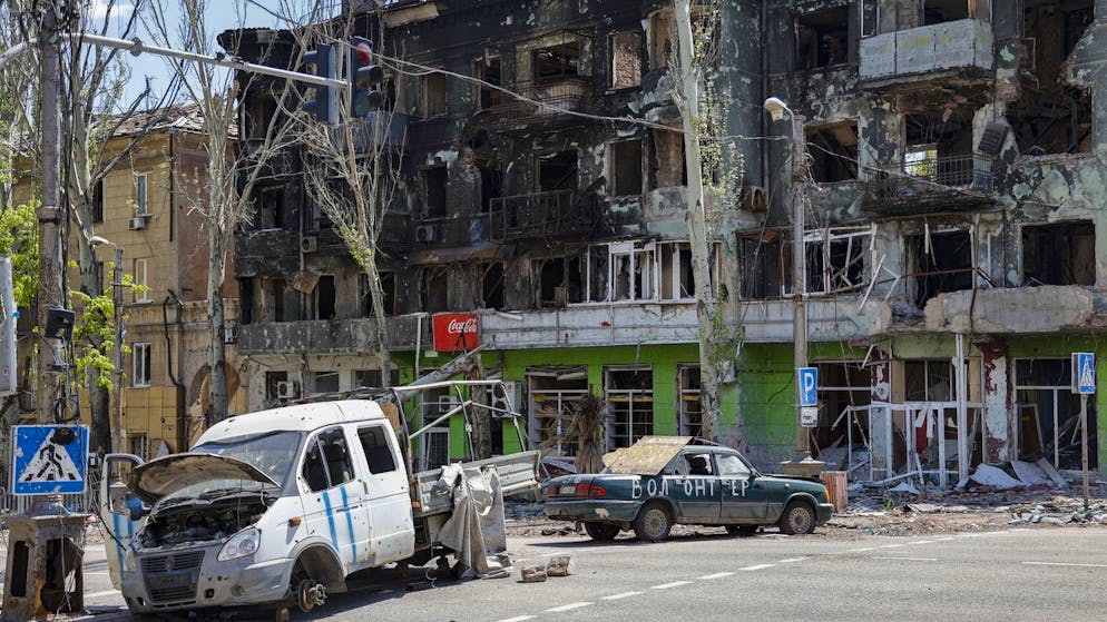 Zerstörte Fahrzeuge und Gebäude am 9. Mai 2022 in Mariupol. 