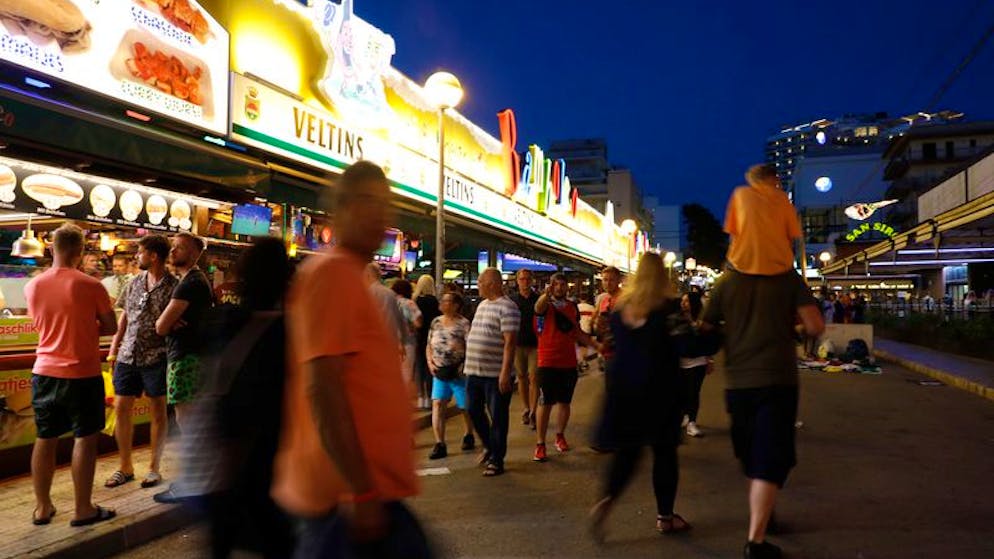 14.05.2022, Spanien, Palma: Menschen gehen neben der Bar Bamboleo in der Bierstraße am Ballermann vorbei. Der Ballermann auf Mallorca feiert sein inoffizielles 50-jähriges Jubiläum. Foto: Clara Margais/dpa +++ dpa-Bildfunk +++