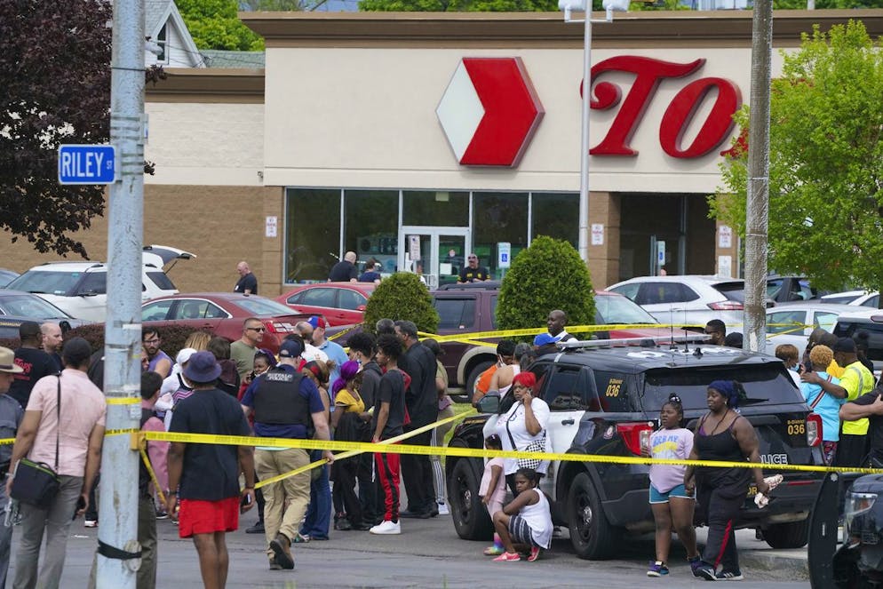 People gather outside a supermarket where at least 10 people were killed in a shooting, Saturday, May 14, 2022 in Buffalo, N.Y. Officials said the gunman entered the supermarket with a rifle and opened fire. Investigators believe the man may have been livestreaming the shooting and were looking into whether he had posted a manifesto online (Derek Gee/The Buffalo News via AP)