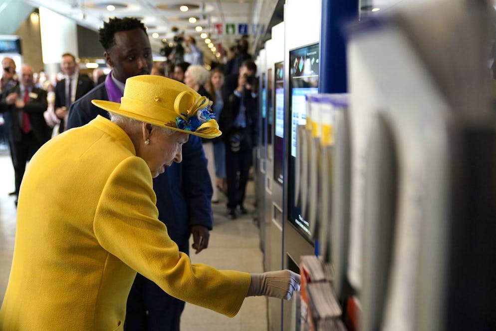Britain's Queen Elizabeth II uses a card machine at Paddington station in London, Tuesday May 17, 2022, during a visit to mark the completion of London's Crossrail project. (Andrew Matthews/Pool via AP)