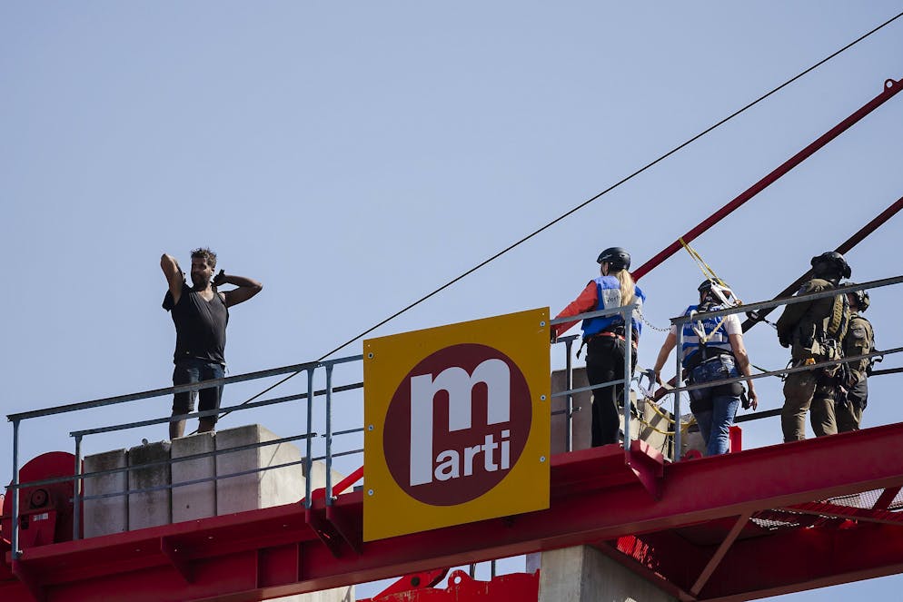 Einsatzkraefte verhandeln mit einem Mann, links, der auf einem Baukran am Bahnhof Oerlikon Feuer entfachte und Gegenstaende herunterwarf, am Dienstag, 17. Mai 2022 in Zuerich. (KEYSTONE/Michael Buholzer)