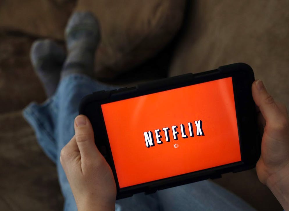 In this Friday, Jan. 17, file photo, a person displays Netflix on a tablet in North Andover, Mass. Netflix is raising its Internet video prices by $1 per month for new customers and giving its current U.S. subscribers a two-year break from the higher rates. (AP Photo/Elise Amendola)