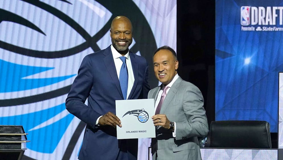 RETRANSMISSION TO CORRECT ID TO JAMAHL MOSLEY - Orlando Magic head coach Jamahl Mosley, left, stands with NBA Deputy Commissioner Mark Tatum after Tatum announced that the Magic have won the first pick in the 2022 NBA draft during the NBA basketball draft lottery Tuesday, May 17, 2022, in Chicago. (AP Photo/Charles Rex Arbogast)