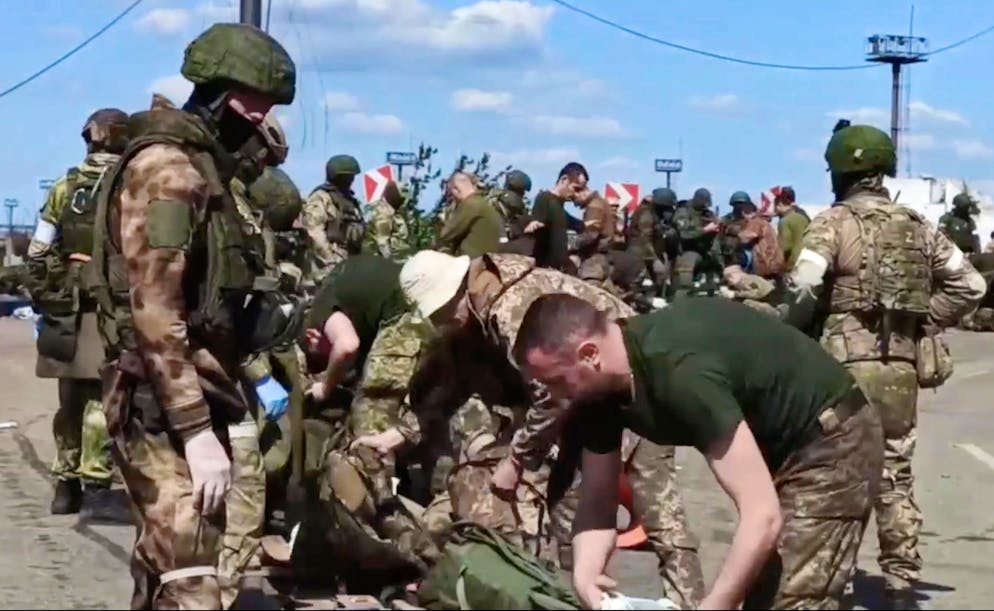 In this photo taken from video released by the Russian Defense Ministry on Friday, May 20, 2022, Russian servicemen frisk Ukrainian servicemen after they leaved the besieged Azovstal steel plant in Mariupol, in territory under the government of the Donetsk People's Republic, eastern Ukraine. (Russian Defense Ministry Press Service via AP)
