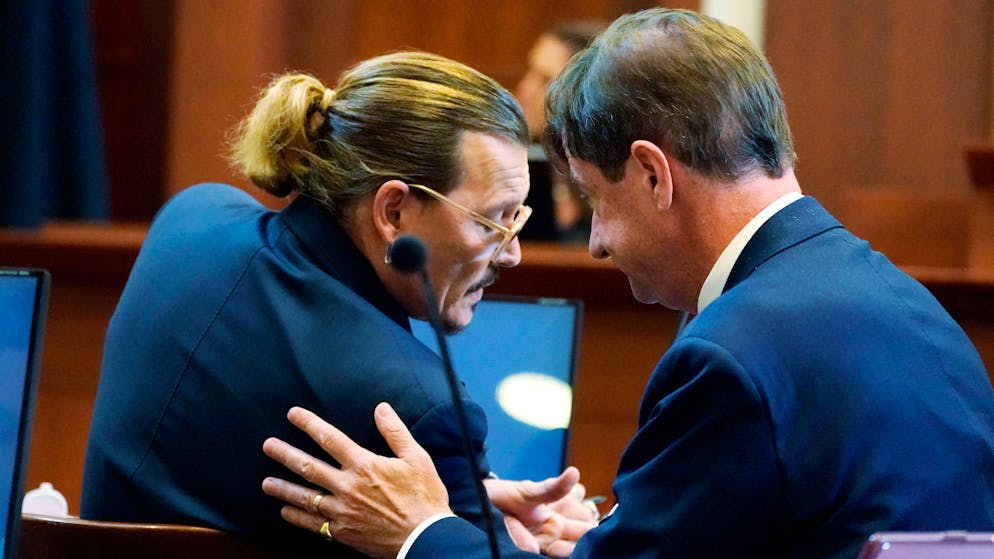 US actor Johnny Depp talks to his attorney Ben Chew in the courtroom at the Fairfax County Circuit Courthouse in Fairfax, Virginia, on May 23, 2022. - Depp sued his ex-wife Amber Heard for libel in Fairfax County Circuit Court after she wrote an op-ed piece in The Washington Post in 2018 referring to herself as a