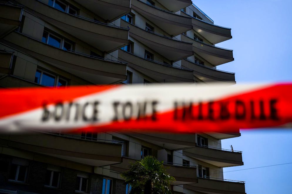 Une rubalise de la police cantonale vaudoise est visible devant es lieux du drame le jeudi 24 mars 2022 a Montreux. Quatre personnes ont ete retrouvees mortes jeudi matin au pied d'un immeuble du centre-ville de Montreux (VD), et une cinquieme se trouve dans un etat grave. Les circonstances du drame ne sont pas encore connues, mais les victimes auraient saute depuis un appartement. (KEYSTONE/Jean-Christophe Bott)