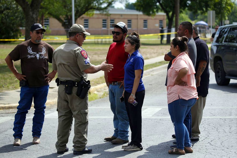 A policeman talks to people asking for information outside of the Robb Elementary School in Uvalde, Texas, Tuesday, May 24, 2022. An 18-year-old gunman opened fire at the Texas elementary school, killing multiple people. Gov. Greg Abbott says the gunman entered the school with a handgun and possibly a rifle. AP Photo/Dario Lopez-Mills)
