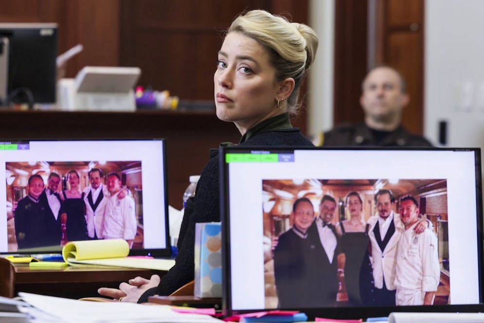 A picture introduced into evidence of actor Johnny Depp and his ex-wife actor Amber Heard with the staff of the Orient Express train taken at the end of their honeymoon trip in Singapore after their wedding in 2015, is displayed on screens in the courtroom in the Fairfax County Circuit Courthouse in Fairfax, Va., Wednesday, May 25, 2022. Depp sued his ex-wife Heard for libel in Fairfax County Circuit Court after she wrote an op-ed piece in The Washington Post in 2018 referring to herself as a 