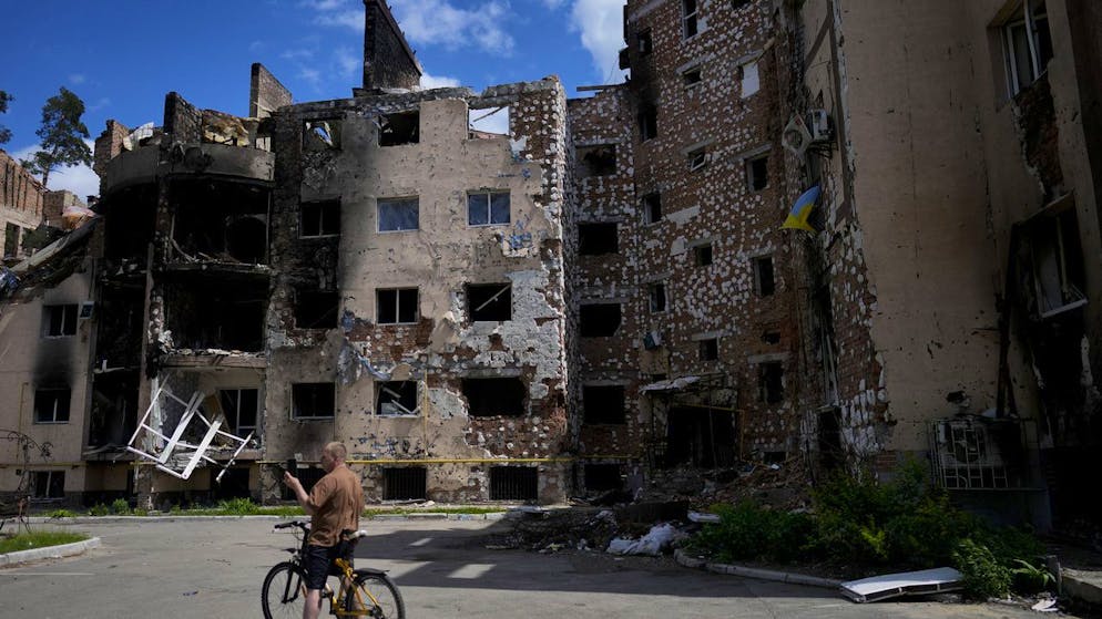 On Thursday, May 26, 2022, a cyclist takes pictures of buildings damaged by the attacks in the Ukrainian suburbs of Irfin.  (AP Photo / Natasha Pisarenko)