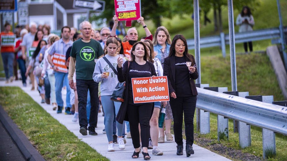 People march along a local street at the end of a vigil to stand in solidarity with the Uvalde, Texas, families and demand an end to gun violence on Thursday, May 26, 2022, in Newtown, Conn. (AP Photo/Eduardo Munoz Alvarez)