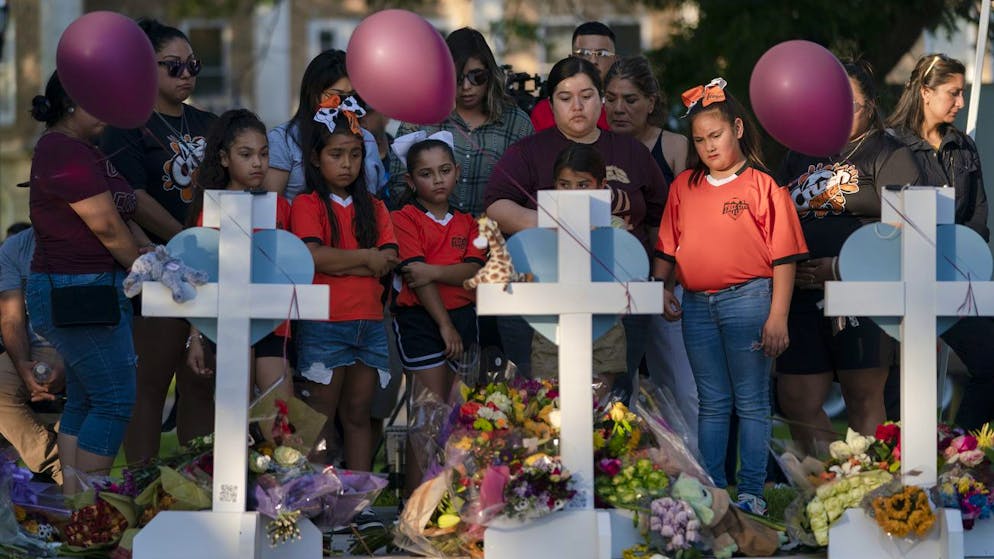People gather at a memorial site to pay their respects for the victims killed in this week's elementary school shooting in Uvalde, Texas, Thursday, May 26, 2022. (AP Photo/Jae C. Hong)