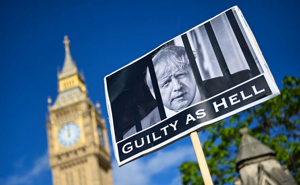 epa09975097 A protester demonstrates against the Downing Street parties, outside parliament in London, Britain, 25 May 2022. British Prime Minister Boris Johnson is under pressure over 'party gate' allegations following new photographs showing him at a drinks party during lockdown. EPA/ANDY RAIN