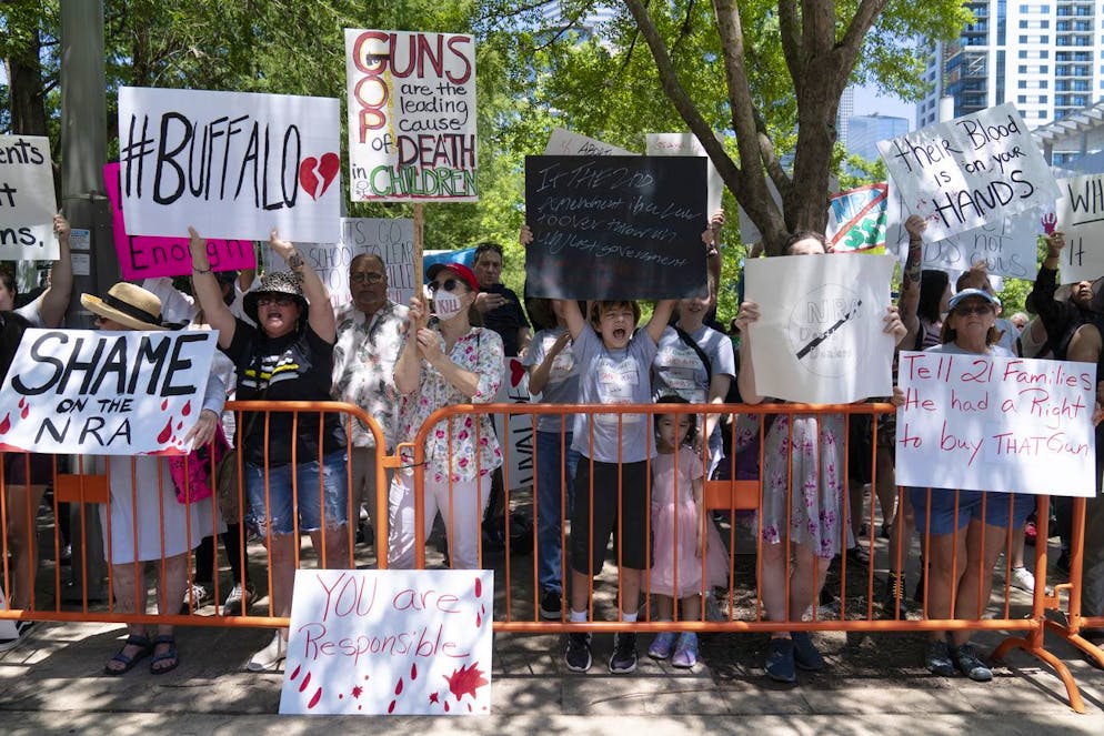 Protesters hold up their signs condemning the National Rifle Association's annual meeting outside the George R. Brown Convention Center in Houston, Friday, May 27, 2022. (AP Photo/Jae C. Hong)