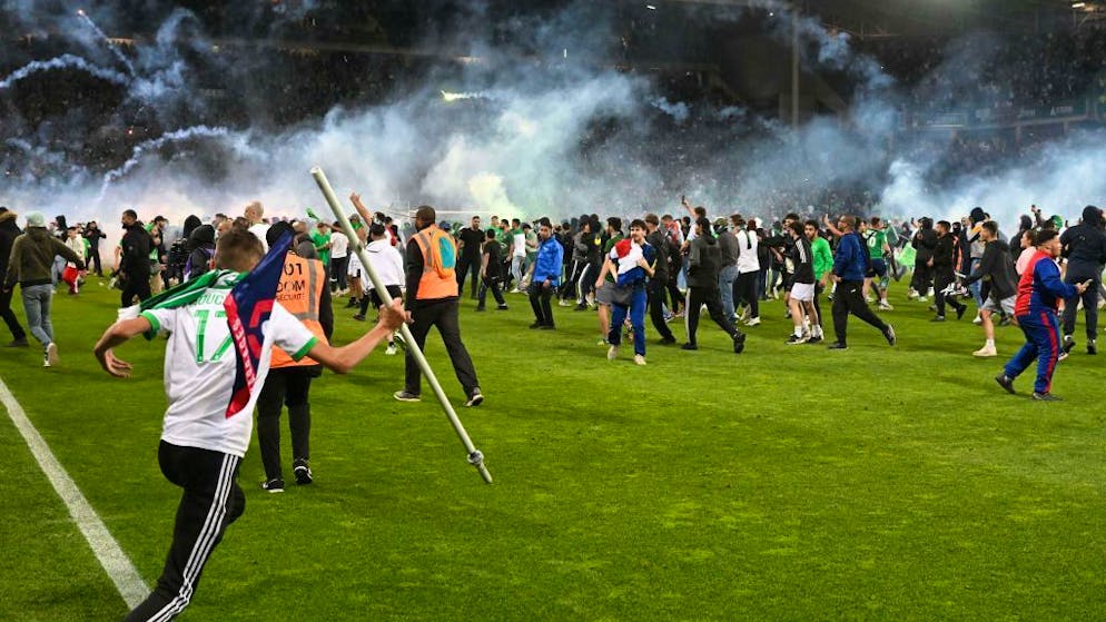 Saint-Etienne's fans invade the pitch after being defeated at the end of the French L1-L2 play-off second leg football match between AS Saint-Etienne and AJ Auxerre at the Geoffroy Guichard Stadium in Saint-Etienne, central-eastern France on May 29, 2022. (Photo by JEAN-PHILIPPE KSIAZEK / AFP) / The erroneous mention[s] appearing in the metadata of this photo by JEAN-PHILIPPE KSIAZEK has been modified in AFP systems in the following manner: [after being defeated] instead of [as they celebrate their team's victory]. Please immediately remove the erroneous mention[s] from all your online services and delete it (them) from your servers. If you have been authorized by AFP to distribute it (them) to third parties, please ensure that the same actions are carried out by them. Failure to promptly comply with these instructions will entail liability on your part for any continued or post notification usage. Therefore we thank you very much for all your attention and prompt action. We are sorry for the inconvenience this notification may cause and remain at your disposal for any further information you may require. (Photo by JEAN-PHILIPPE KSIAZEK/AFP via Getty Images)