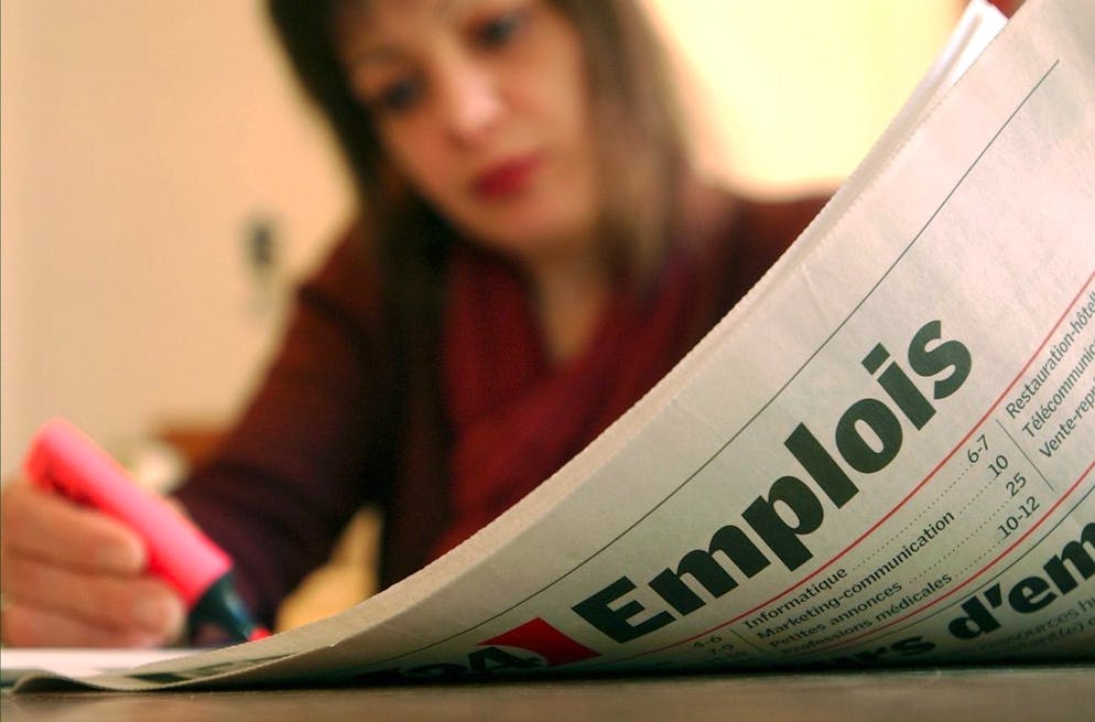 Unejeune femme regarde les offres d'emploi dans un quotidien a Martigny, ce vendredi 8 novembre 2002. Le peuple suisse sera appele aux urnes le 24 novembre 2002 pour se prononcer sur la loi sur l'assurance chomage. (KEYSTONE/Andree-Noelle Pot)